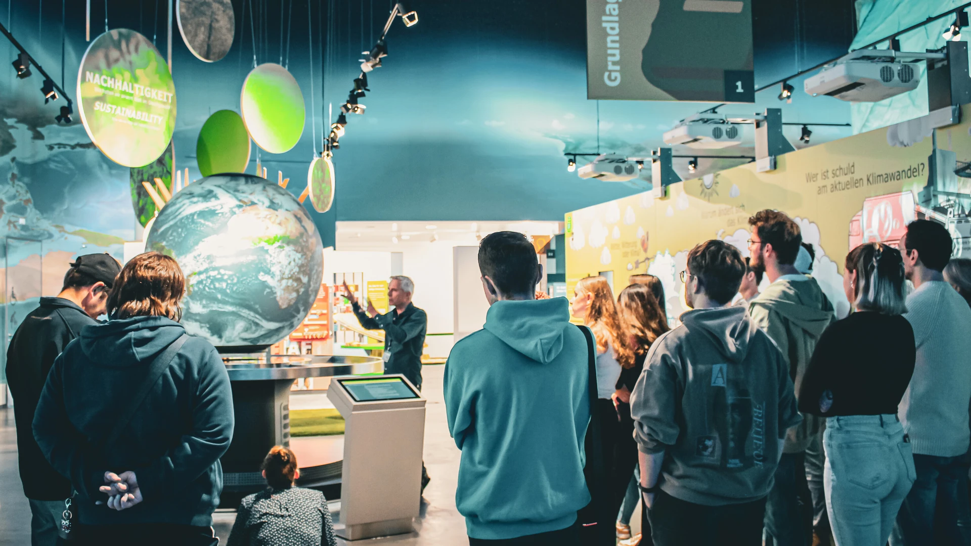 Lehramsstudierende bei einer F&uuml;hrung am interaktiven Globus.