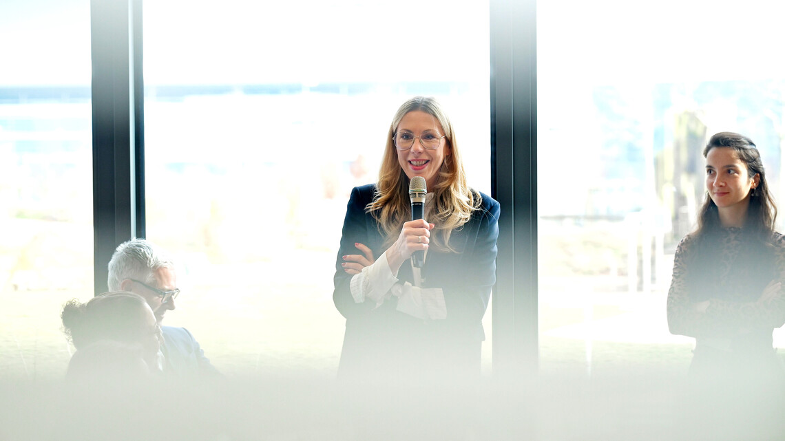 Eine Frau mit Mikrofon w&auml;hrend einer Veranstaltung in der Klima Arena